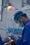 person in blue scrub suit holding clear glass cup